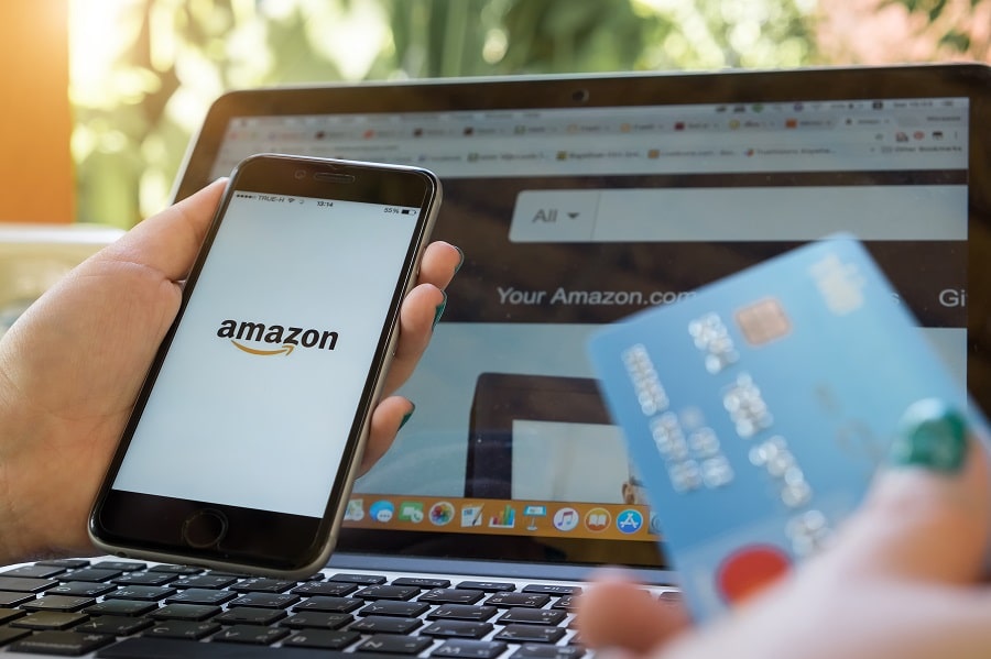 Una persona che utilizza una carta di credito o debito per effettuare un pagamento su Amazon