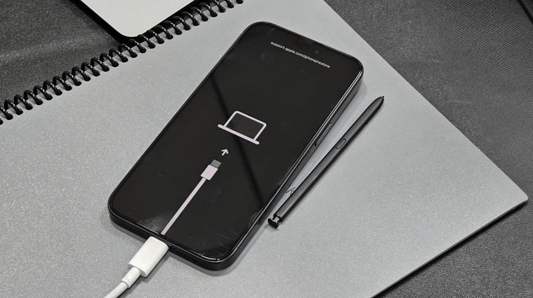 Sie sehen ein Kabel auf dem schwarzen Bildschirm, das auf Ihren Laptop zeigt und anzeigt, dass Ihr iPhone jetzt im Wiederherstellungsmodus ist.